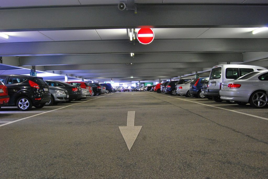 Carros perfilados em estacionamento coberto | Club Coworking
