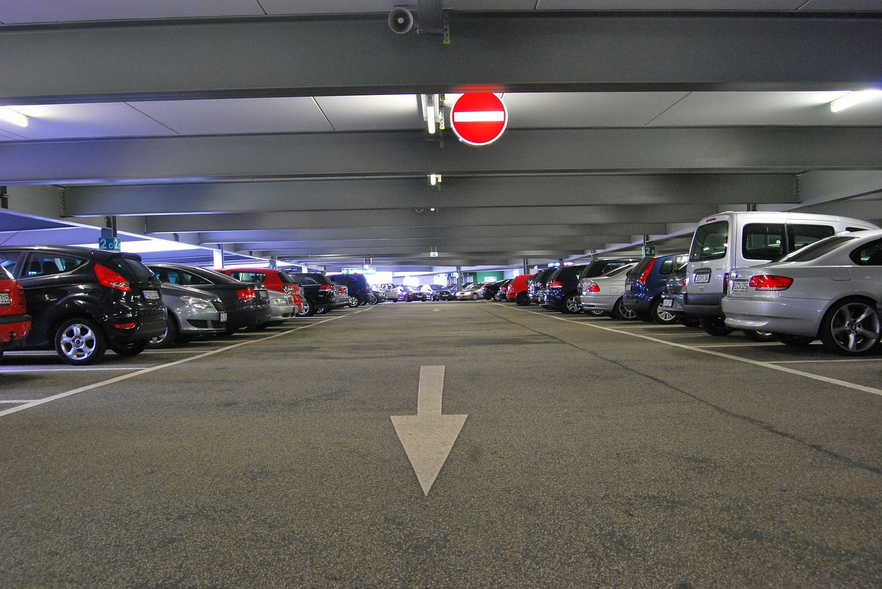 Carros perfilados em estacionamento coberto | Club Coworking