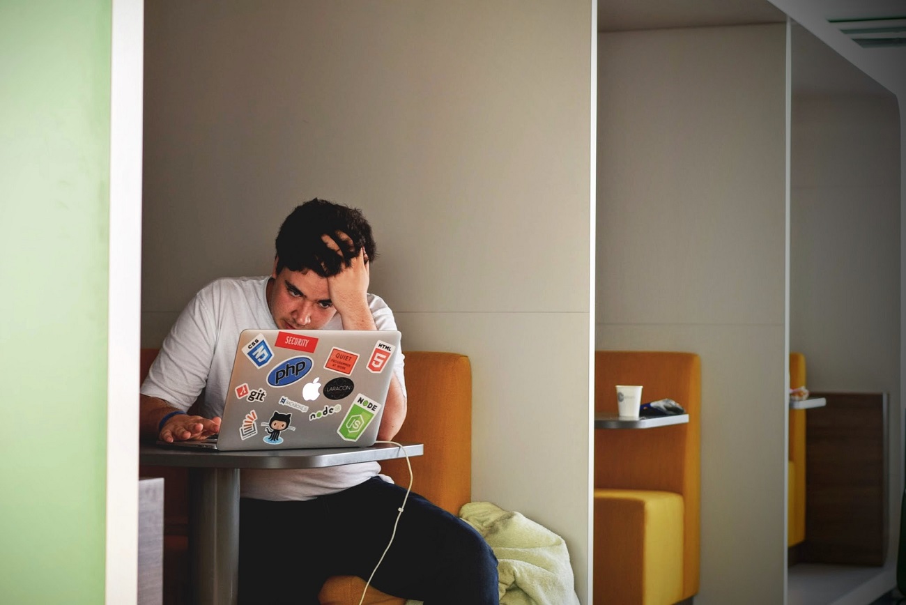 Homem trabalha cansado na frente do computador