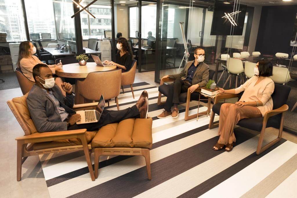 Pessoas de máscara em espaço coworking. Essa é uma das possibilidades do anywhere office